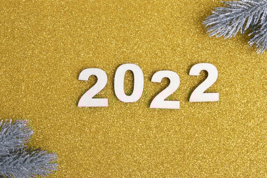 Wooden numbers new year 2022 on golden glitter background photo