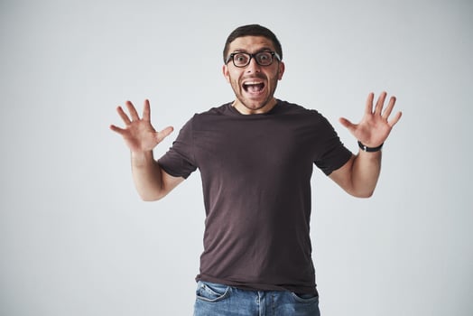 Emotional man in casual clothes screams in pain or with fear. His feelings are overwhelming photo