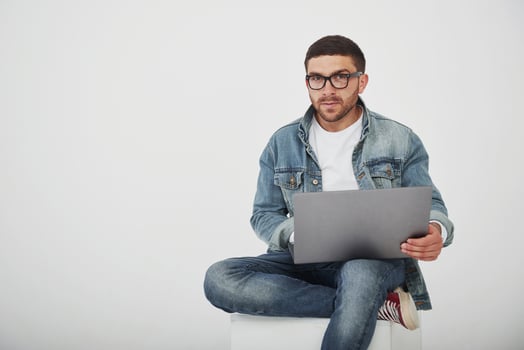 Handsome young man with laptop and check his timetable on white background photo