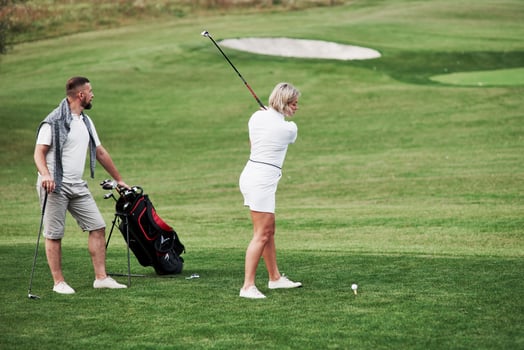 Trying to hit the ball. Couple of golf players have good game in their weekend time photo