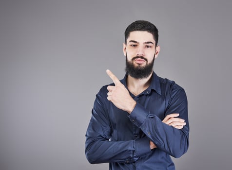 Cheerful handsome man showing direction and pointing with finger photo