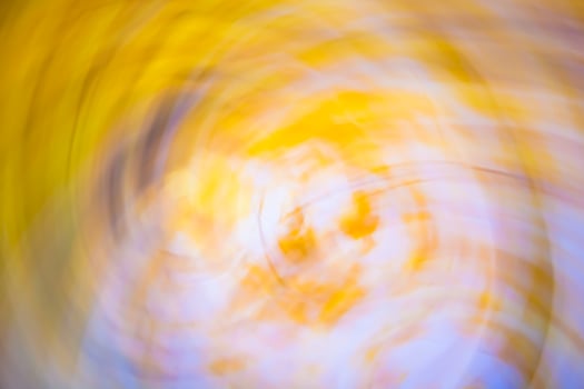 Horizontal abstract twisted background of motion blurred yellow leaves and sky. photo