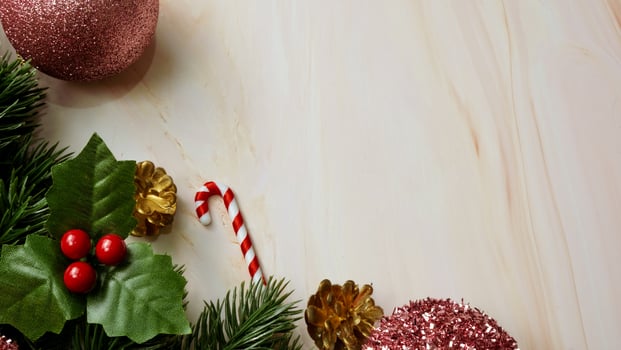 Green pine tree leaves, pink christmas decorations and candy canes on soft marble background, christmas decorations in bright and fancy pink color. Simple and creative christmas concept. photo