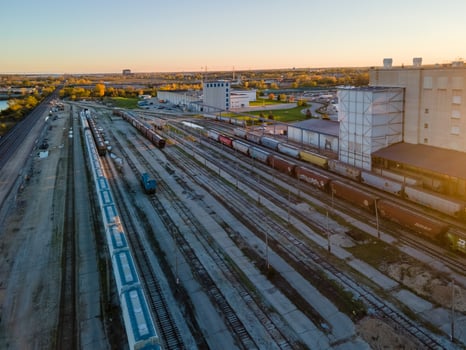 aerial view of rail yard switching station and urban buildings at sunset photo