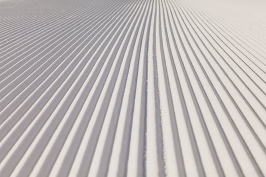 Texture of new groomed snow on empty ski slope photo