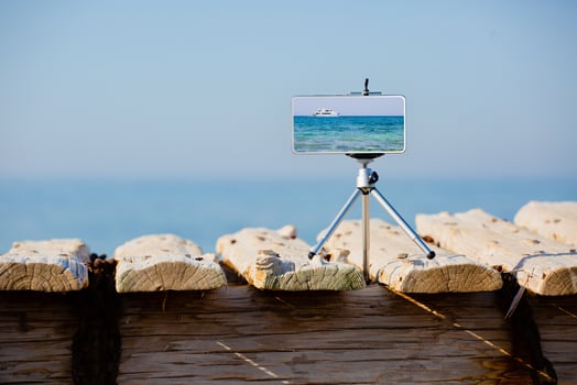 Smartphone on tripod making photo and video of sea landscape