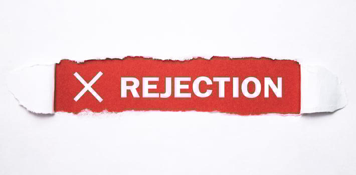 Rejection word on torn paper. photo