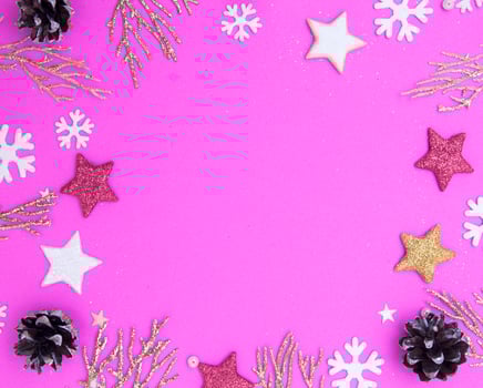 Christmas flat lay with empty place for text. Golden twigs, stars, snowflakes, cones on a pink background. photo