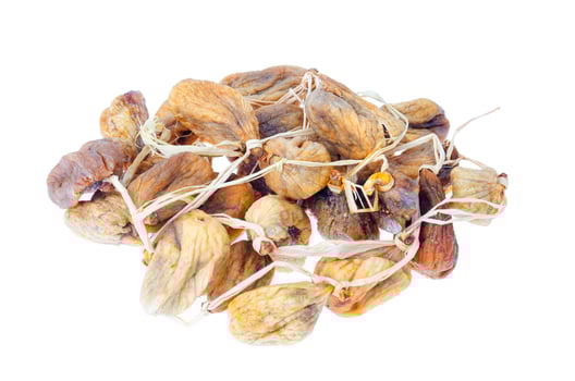 Pile of dried figs on rope isolated on white background. Studio Photo