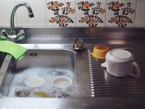 hand dish washing in kitchen sink with detergent foam photo