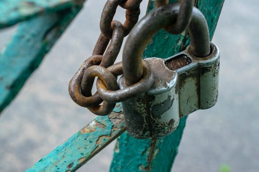 Old gray padlock on a chain. Vintage lock close up. photo