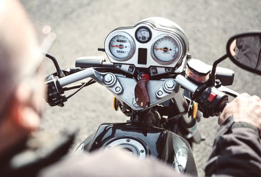 Senior man steering motorcycle on road photo