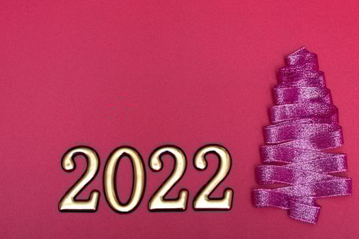 Christmas concept. Purple Christmas tree made from ribbons and gold numbers on a pink background with copy space on top. Template for postcards, packaging. photo