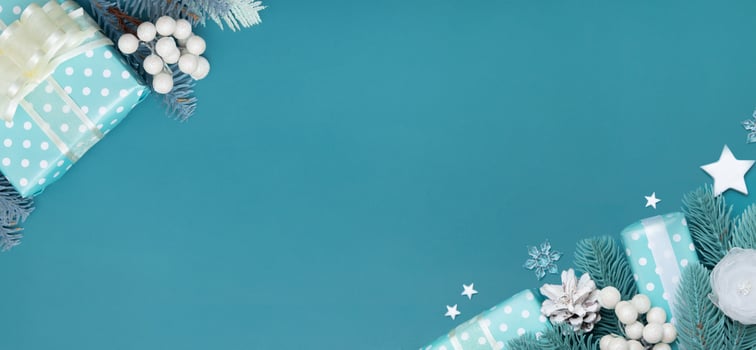 Merry Cristmas greeting banner with flat lay Christmas gift, berries and pine turquoise background copy space photo