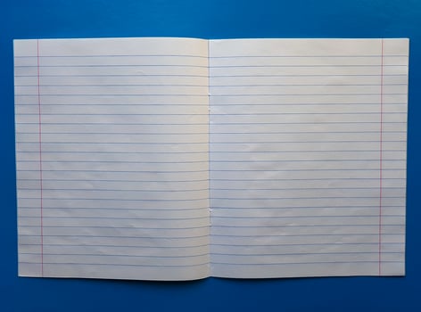 Open notebook on a white lining on a blue wooden tabletop photo