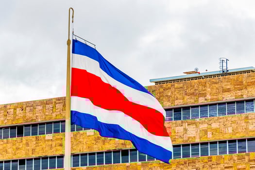Flag of Costa Rica old buildings behind Costa Rican flag. photo