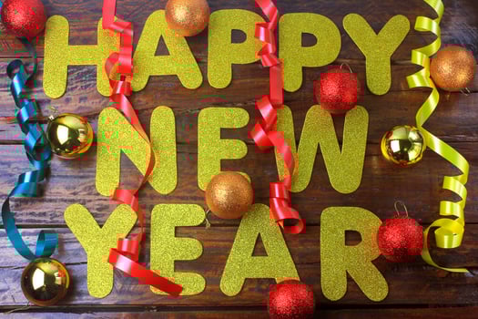 Happy new year celebration poster, welcome message with ornaments on wooden background photo