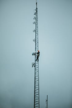 Telecom Worker Climbing Antenna Tower photo