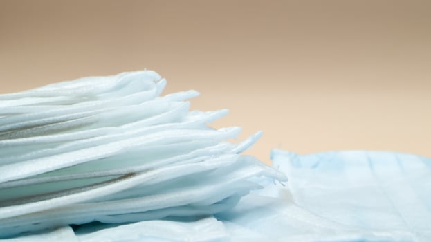 Coronavirus protection. Antiviral protective medical face masks with ear loops. Surgical mask background. Respiratory syndrome, coronavirus disease COVID-19. Many folded medical masks. photo