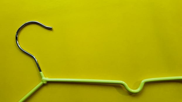 Hanger for clothes on a yellow background. Green hanger. Background with copy space. Black friday, shopping day photo