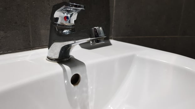 white ceramic washbasin with chrome faucet in the toilet with gray tile photo