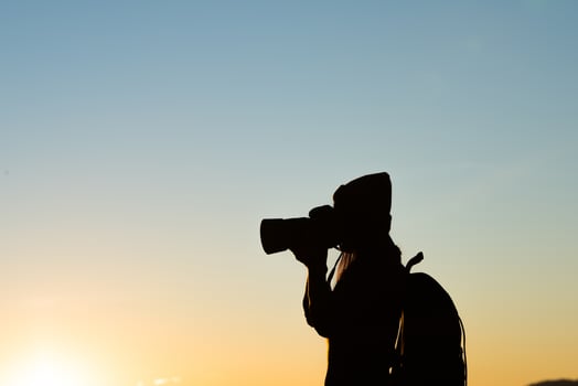 Silhouette of tourist woman standing in the mountain photo