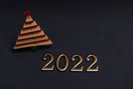 New Year's composition. Brown paper christmas tree with golden numbers 2022 on black background with copy space. photo