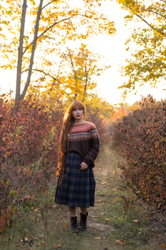 Young woman with red dreadlocks and wearing a sweater in the beautiful autumn forest photo