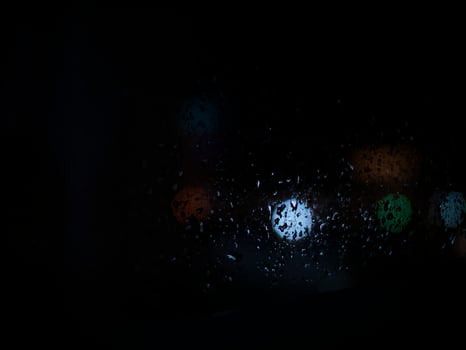 Raindrops on glass in the background of the night photo