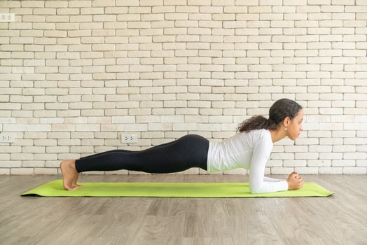 Latin woman practicing yoga on mat photo