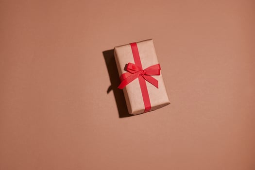 Valentine day composition. Present or gift box wraped in craft paper with heart on pastel background photo