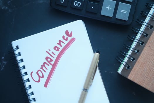 close up of hand written Compliance text on notepad photo