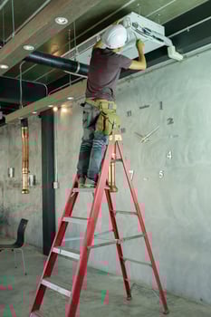 Service man technician repairing air conditioner on the ceiling photo