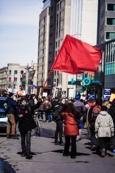 MONTREAL, CANADA APRIL 02 2015 - Protester Agitating a Red Flag in the Street photo