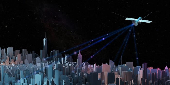 Transmitting signals through communications satellites in the sky and the capital city with tall buildings photo