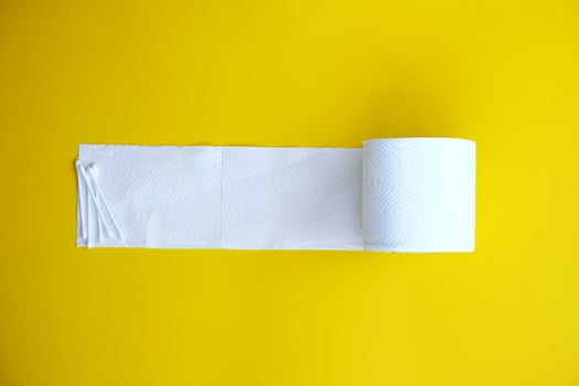Toilet paper isolated on yellow background and healthcare concept photo