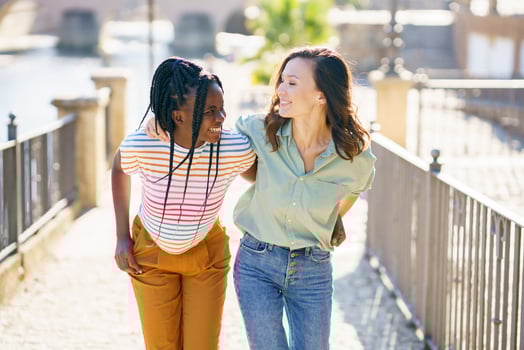 Two Multiethnic women walking together on the street. photo