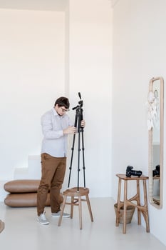 Male photographer working in minimal light and airy interior photo