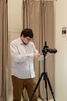 Male photographer working in minimal light and airy interior photo