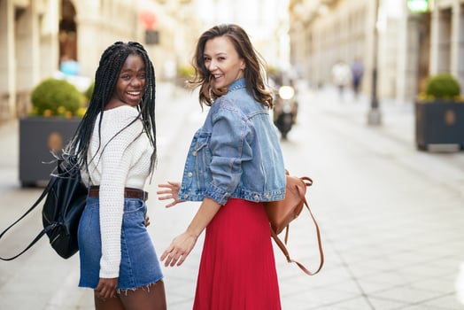Two female friends having fun together on the street. Multiethnic friends. photo