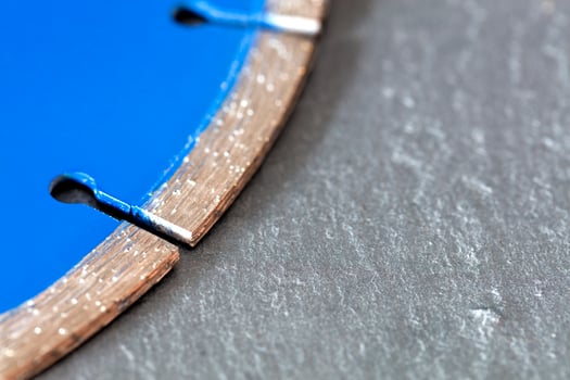 Segment of a diamond cutting disc on a background of gray concrete. photo
