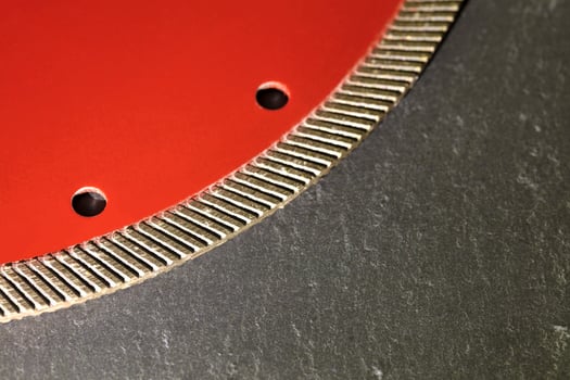 Segment of a diamond cutting disc on a background of gray concrete. photo