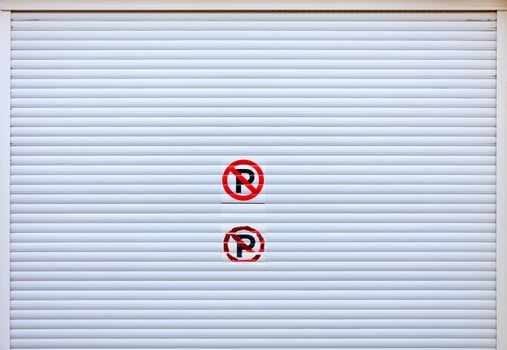 Large white metal shutters at the entrance to the car parking. photo