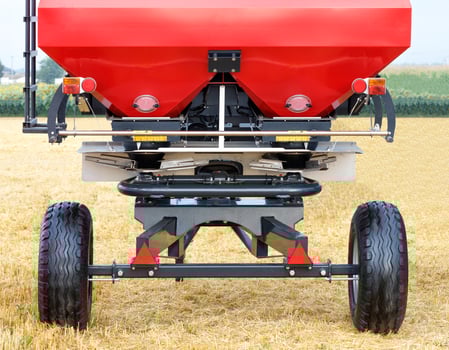 Agricultural equipment, red fertilizer spreader, hitch on the background of a yellow field. photo