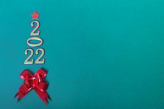 Holiday concept. Christmas background, golden numbers 2022 with red bow and star. Happy New Year. Vertical photo