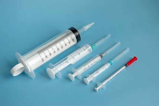 Medical concept of disposable syringes of different volumes on a blue background. photo