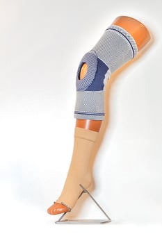 A knee brace on the mannequin's leg for stabilization and relief of the knee joint. photo