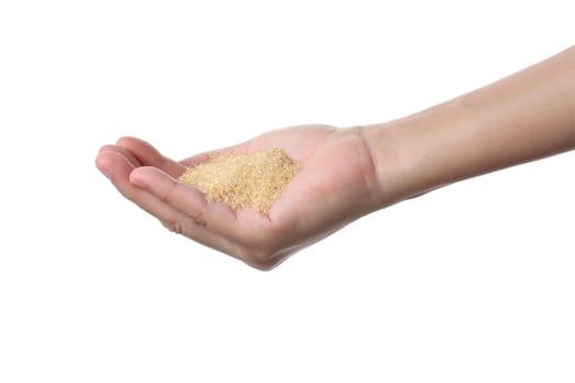 Hand holding brown sugar on white background photo