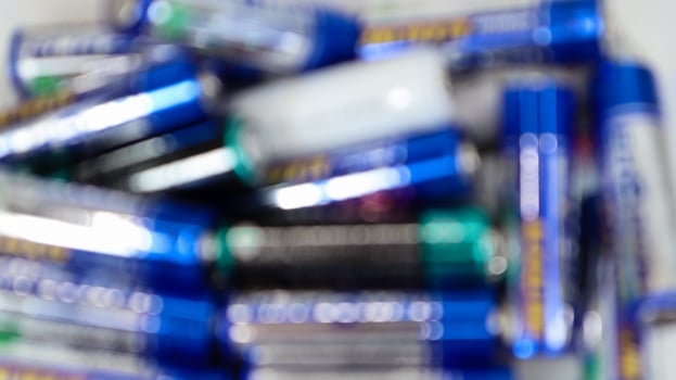 Defocused multicolored random batteries on a AA table, top view. photo
