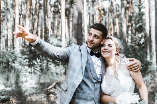 the bride and groom embrace in the forest on the wedding day. wedding ceremony. selective focus. film grain. photo